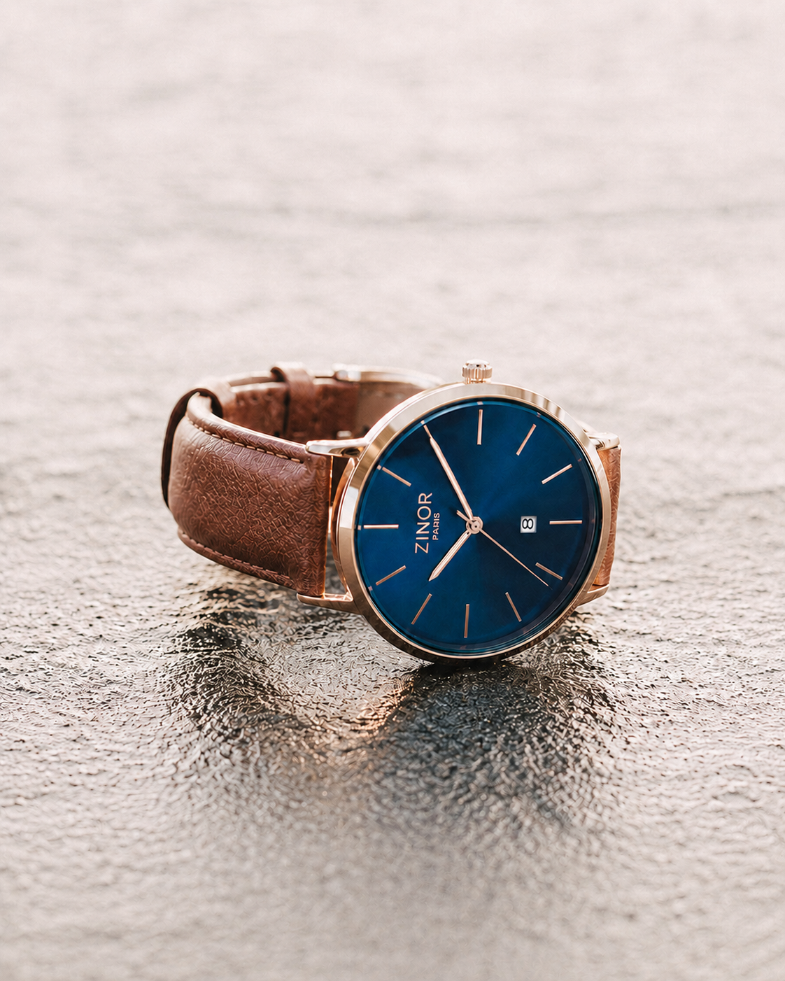 Montre homme ZINOR PARIS Élégance — First Edition, cadran bleu nuit, finition rose gold et bracelet cuir cognac sur surface texturée.